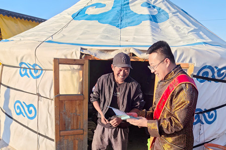 图-宣传人员在太仆寺旗贡宝拉格苏木包恩本嘎查向当地牧民发放金融知识折页 丁彦 摄.jpg